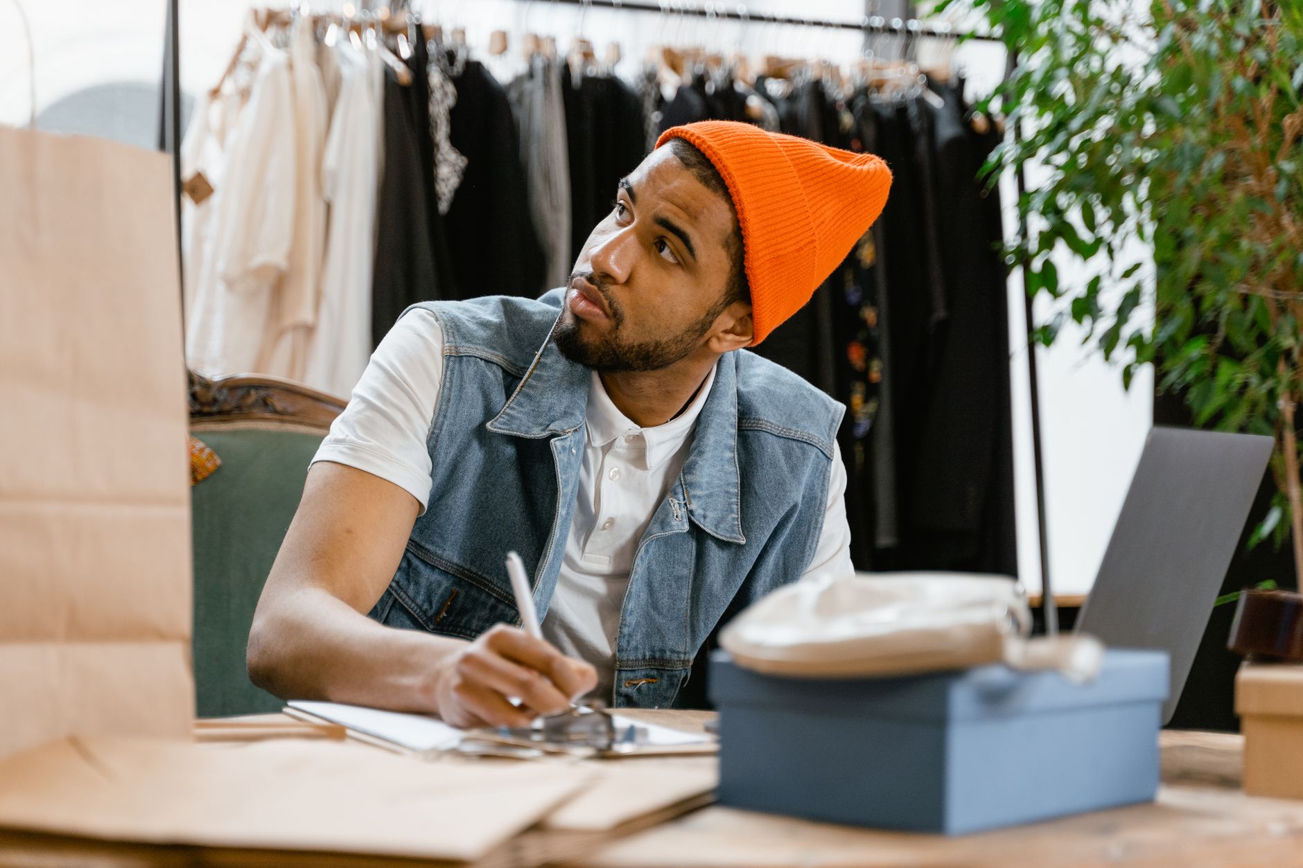Un commerçant indépendant prend des notes sur une fiche de boutique, prêt à corriger ses informations en ligne.